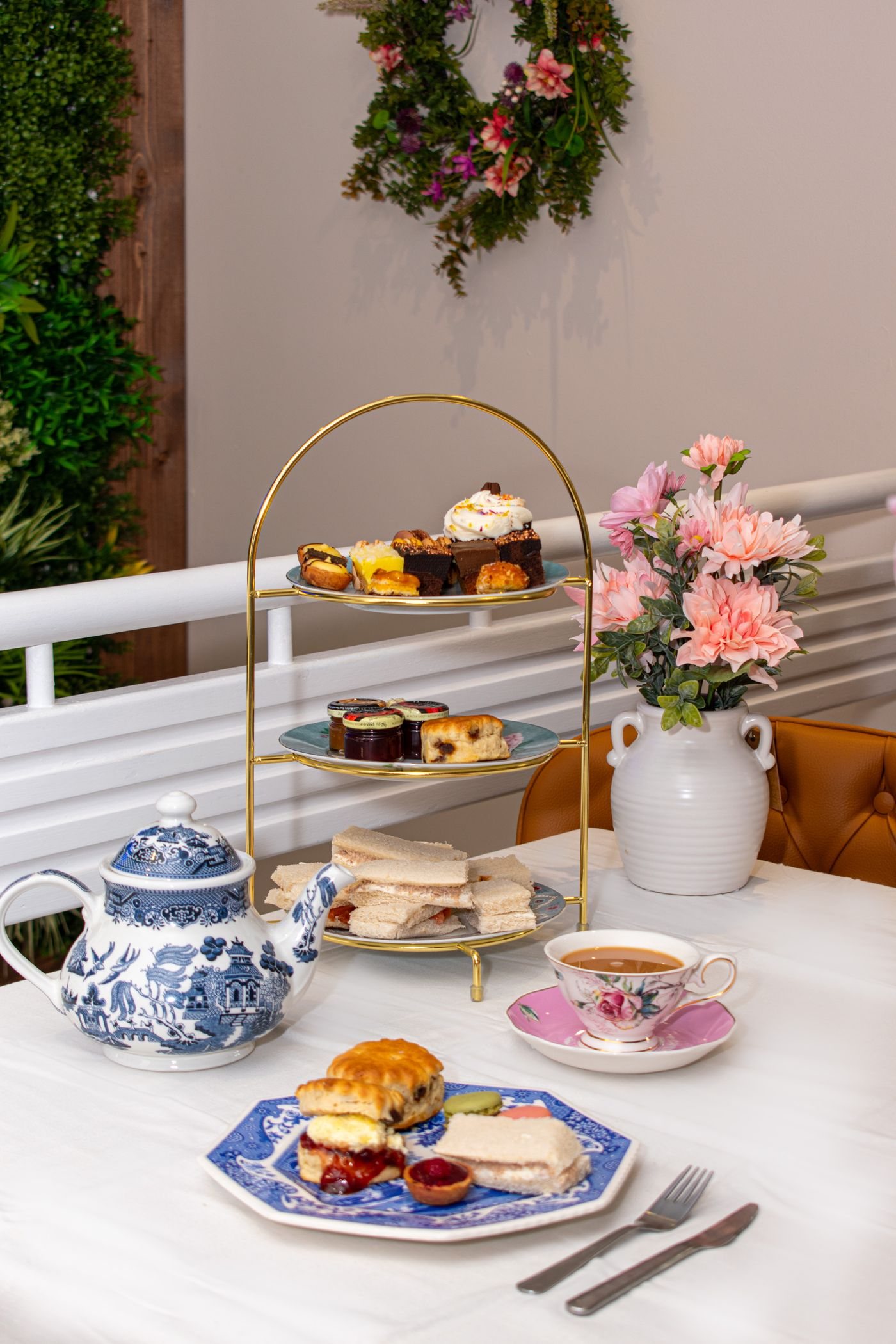 An afternoon tea table with cakes and china cups