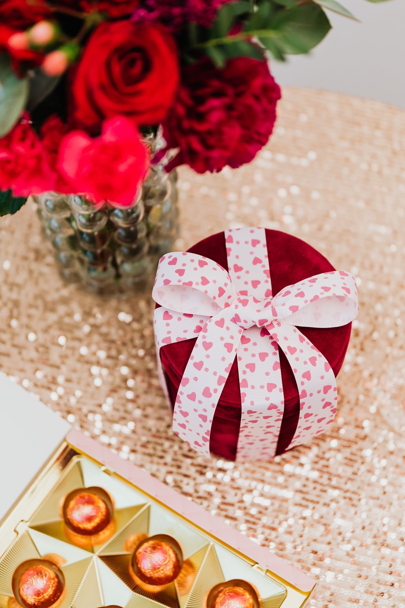 A gift arranged beside chocolates and flowers