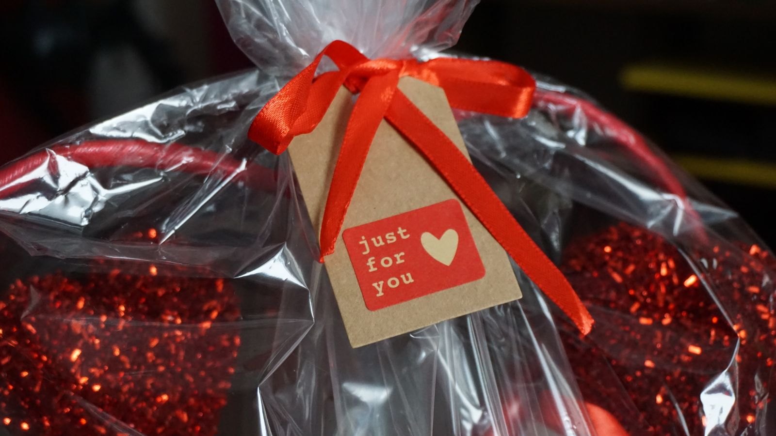 A wrapped gift basket with ribbon and a small tag