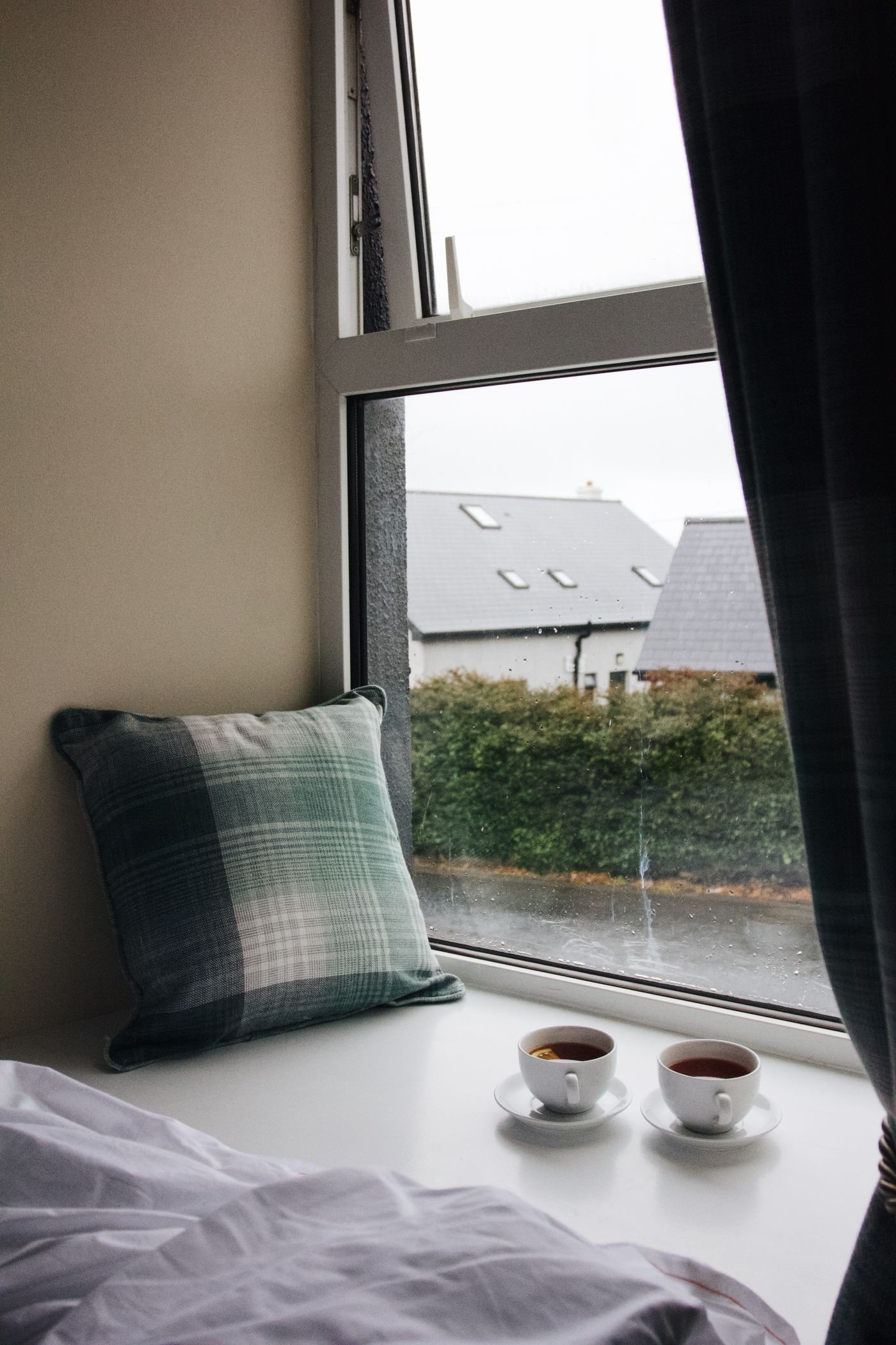 Two cups of tea beside a bright window
