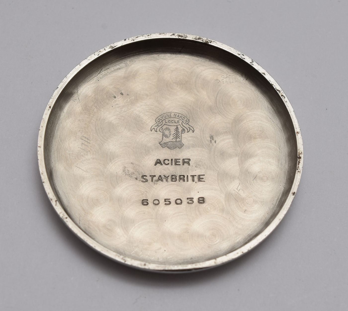 The engraved metal back of a wristwatch
